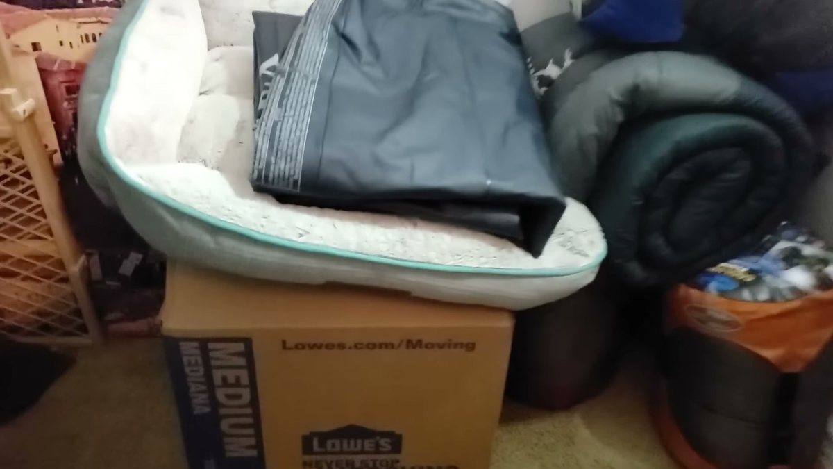 A pile of camping gear and a moving box hiding a safe
